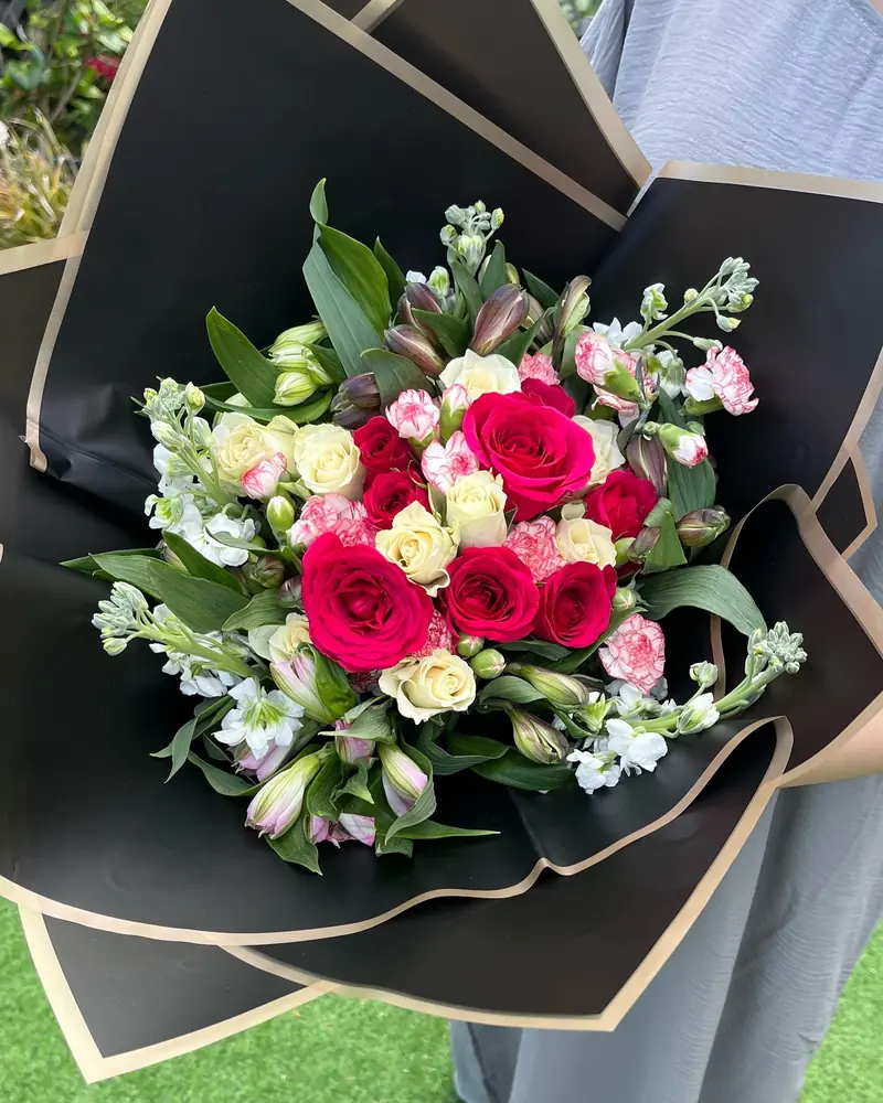 Pink rose and stock bouquet in black wrap